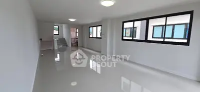 Spacious modern living room with large windows and glossy tiled floors