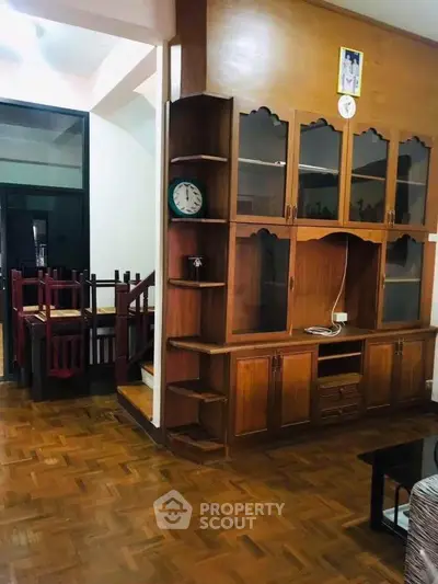 Charming wooden interior with built-in shelves and parquet flooring, perfect for cozy living.