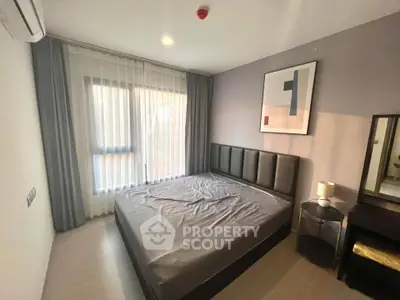 Modern bedroom with stylish decor and natural light, featuring a comfortable bed and elegant furnishings.