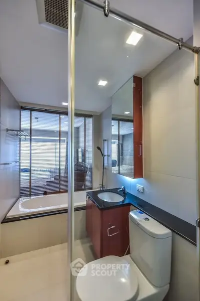 Modern bathroom with glass shower and bathtub in luxury apartment