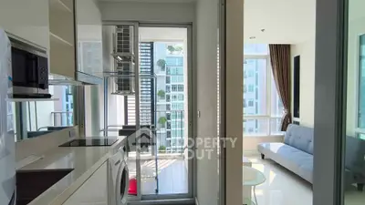 Modern apartment with sleek kitchen and bright living room, featuring large windows and city views.
