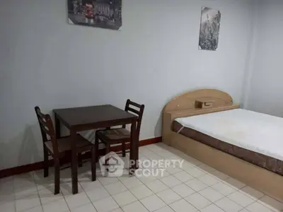 Cozy bedroom with minimalist furniture and tiled flooring, perfect for a comfortable living space.
