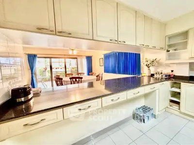 Spacious kitchen with open layout and dining area, featuring elegant cabinetry and ample natural light.