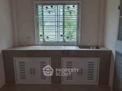 Modern kitchen with sleek cabinetry and large window for natural light.