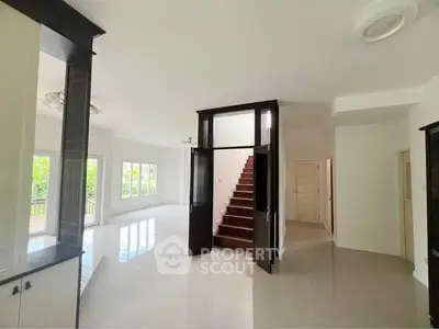 Spacious modern living area with staircase and large windows