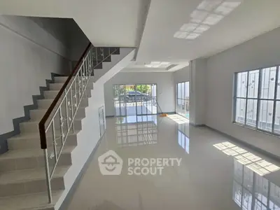 Spacious modern living room with staircase and large windows