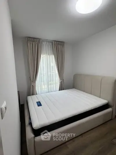 Cozy bedroom with elegant curtains and a comfortable bed, perfect for relaxation.