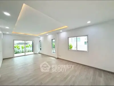 Spacious modern living room with large windows and elegant ceiling lighting