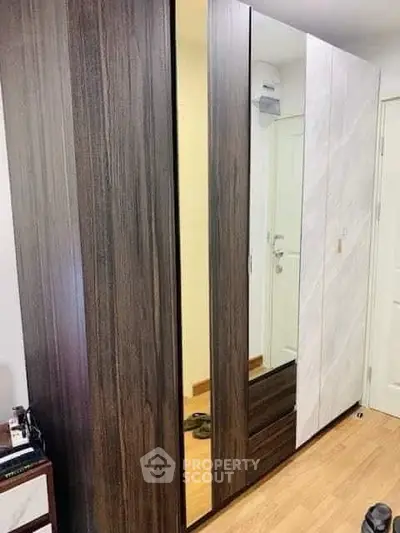 Modern wardrobe with mirrored doors in a stylish bedroom setting.