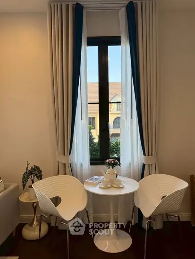 Charming interior with elegant seating by a window, perfect for cozy conversations.