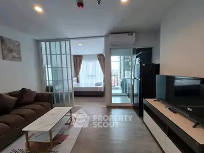 Modern open-plan living room with stylish furniture and balcony view in a contemporary apartment.