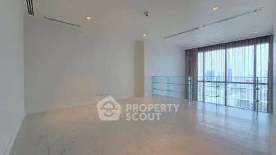 Spacious modern living room with large windows and city view, featuring elegant marble flooring.
