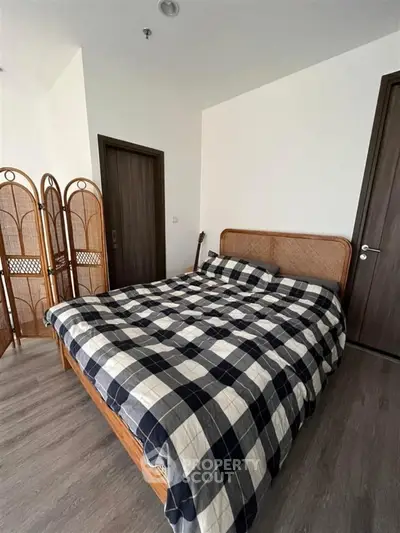 Cozy bedroom with stylish wooden bed and checkered bedding