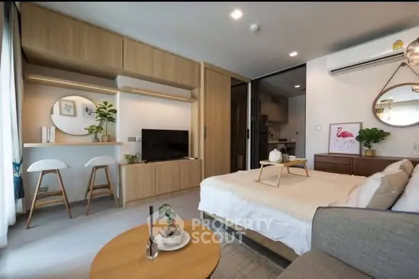 Modern studio apartment with stylish decor and open layout, featuring cozy living area and functional kitchen.