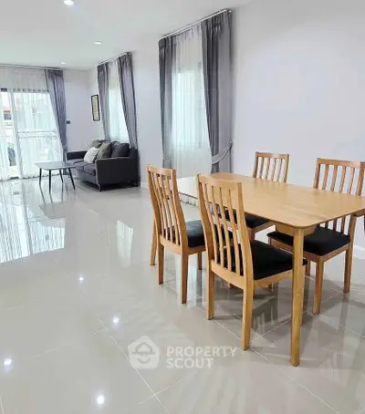 Spacious modern living room with elegant dining area and large windows for natural light.