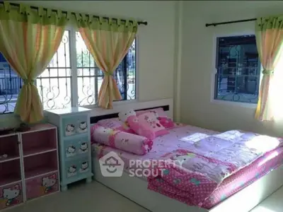 Charming bedroom with playful decor and ample natural light, perfect for a cozy and inviting atmosphere.