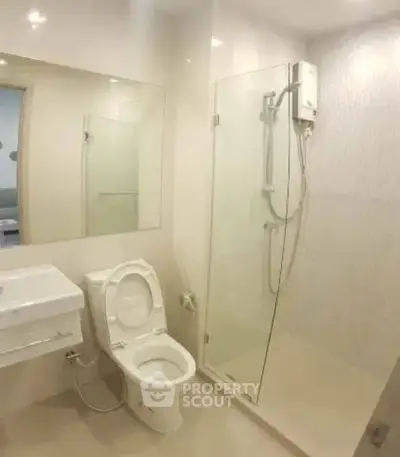 Modern bathroom with glass shower and sleek fixtures in a contemporary home.