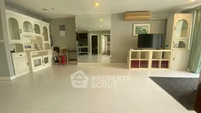 Spacious living room with modern furniture and large mirror, perfect for relaxation and entertainment.