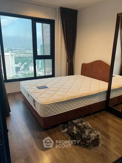 Modern bedroom with large window offering stunning city view, featuring a comfortable bed and elegant decor.