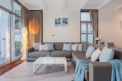 Spacious modern living room with large sectional sofa and floor-to-ceiling windows.