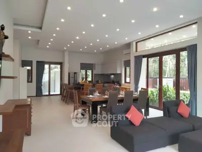 Spacious open-plan living and dining area with modern kitchen and large windows.