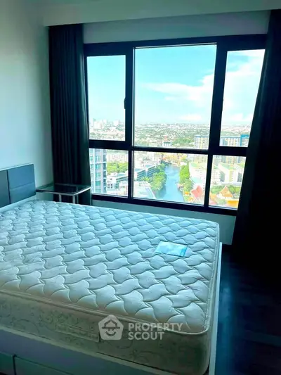 Spacious bedroom with stunning city view from large window, featuring a comfortable bed and modern decor.