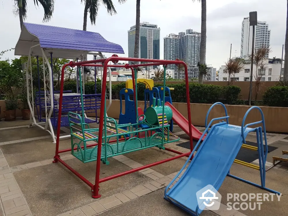 Modern urban playground with colorful slides and swings in a residential complex.