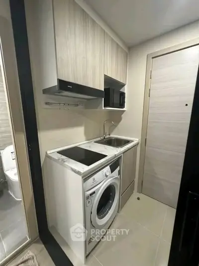 Compact modern kitchen with washing machine and sleek cabinetry