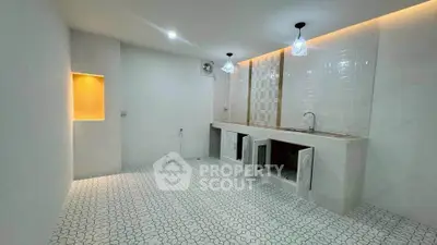 Modern minimalist kitchen with white tile flooring and sleek countertops.