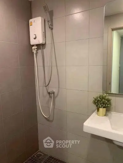 Modern bathroom with sleek shower and stylish sink in contemporary apartment.