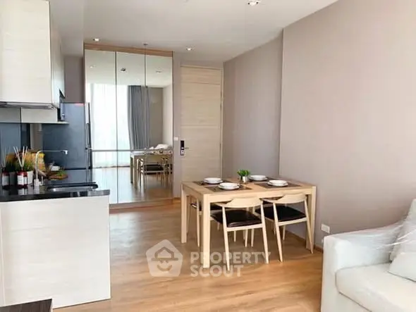 Modern open-layout living room with dining area and sleek kitchen in a stylish apartment.