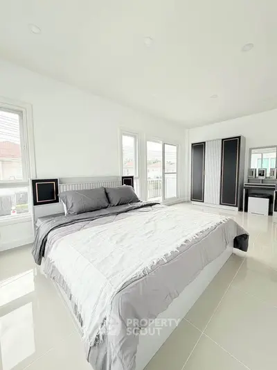 Spacious modern bedroom with large windows and sleek furnishings