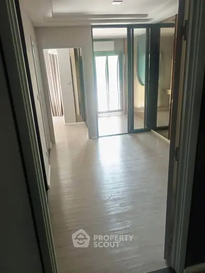 Spacious hallway with wooden flooring and large windows in modern apartment