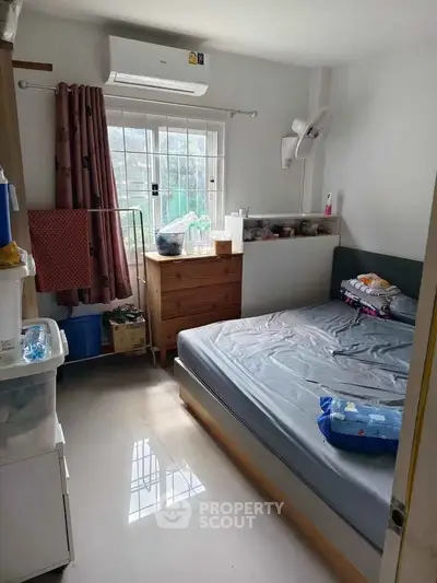 Cozy bedroom with natural light and modern furnishings, ideal for comfortable living.