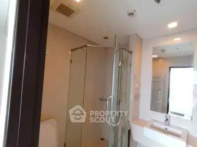 Modern bathroom with glass shower and sleek fixtures in a contemporary apartment.