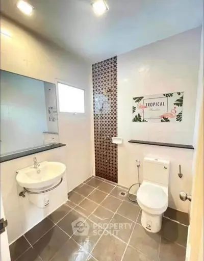 Modern bathroom with stylish tile accent wall and sleek fixtures in a bright, inviting space.