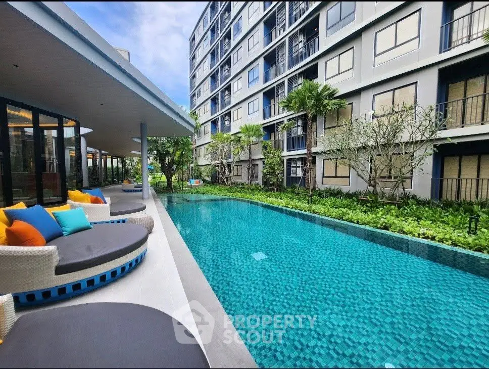 Luxurious apartment complex with stunning poolside view and modern outdoor seating.