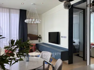 Modern living room with elegant decor and natural light, featuring a stylish chandelier and open layout.