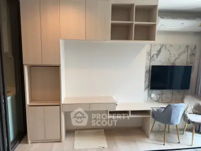 Modern living room with built-in wooden shelves, wall-mounted TV, and stylish seating.