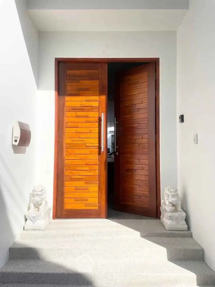 Elegant wooden entrance door with decorative statues, inviting modern design