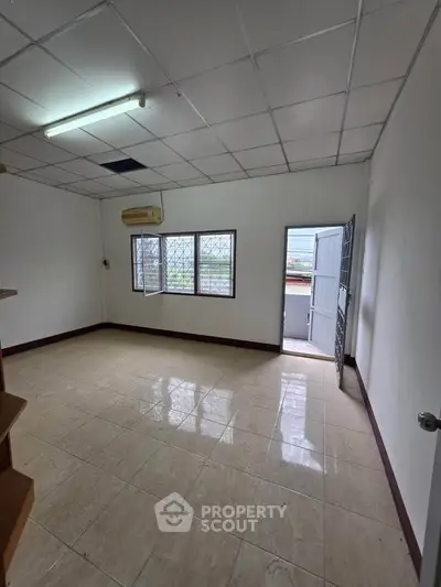 Spacious unfurnished room with tiled flooring and natural light, ideal for customization.