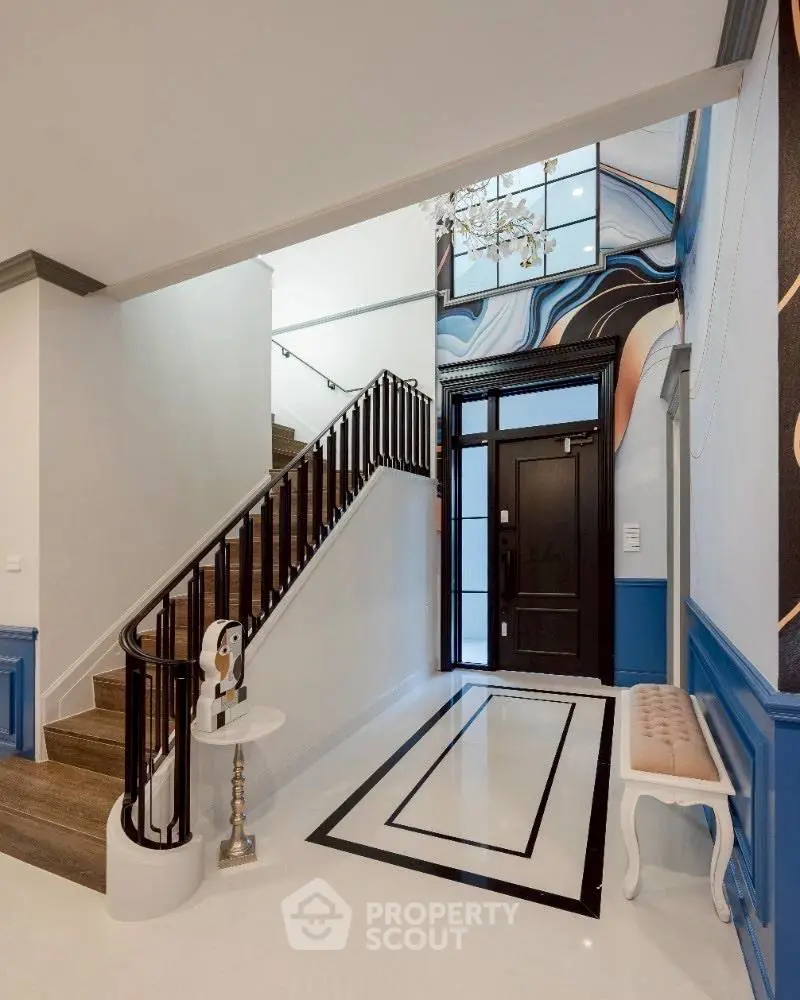 Elegant entrance with modern staircase and stylish decor in a luxury home