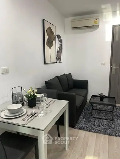 Cozy living room with modern decor and dining area in a compact apartment setting.