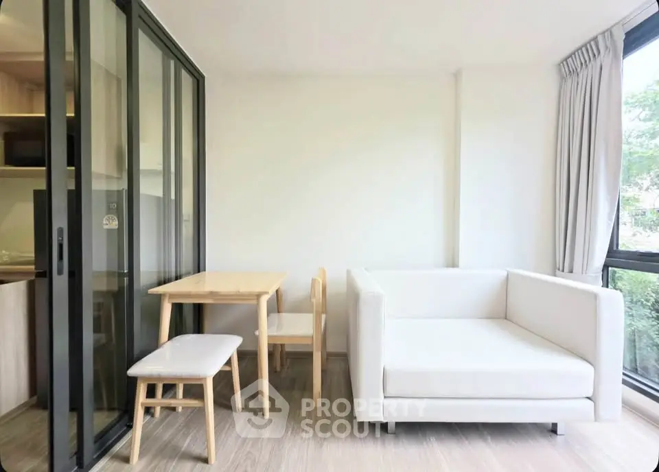 Modern living room with sleek glass partition and cozy dining area