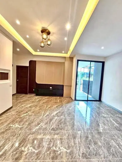 Spacious modern living room with elegant lighting and marble flooring, featuring a sliding glass door to a balcony.