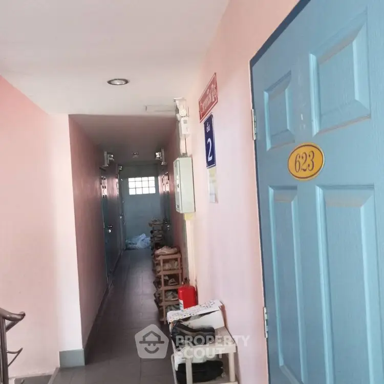 Charming corridor with pastel walls and numbered doors, ideal for cozy apartment living.