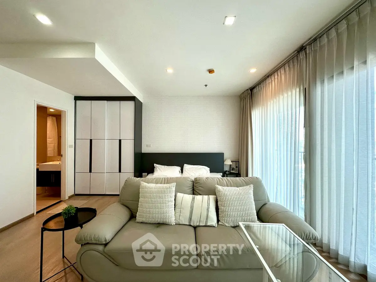 Modern living room with cozy sofa and large windows in a stylish apartment.