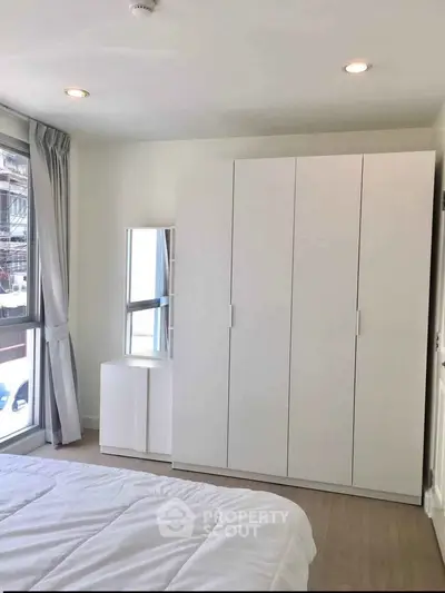 Bright and modern bedroom with large wardrobe and natural light.