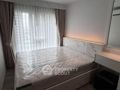 Modern bedroom with large window and elegant curtains in a stylish apartment.