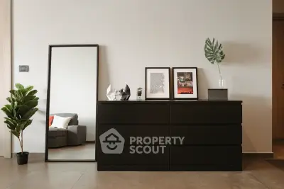 Modern interior with sleek dresser, mirror, and stylish decor in a contemporary living space.